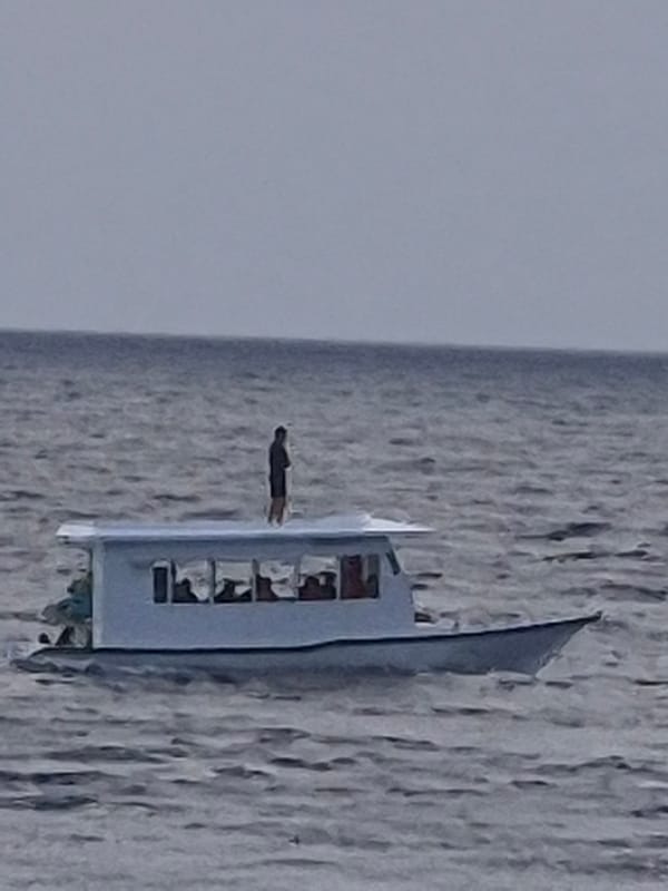 Passenger vessel sails near Huraa, Maldives shoreline