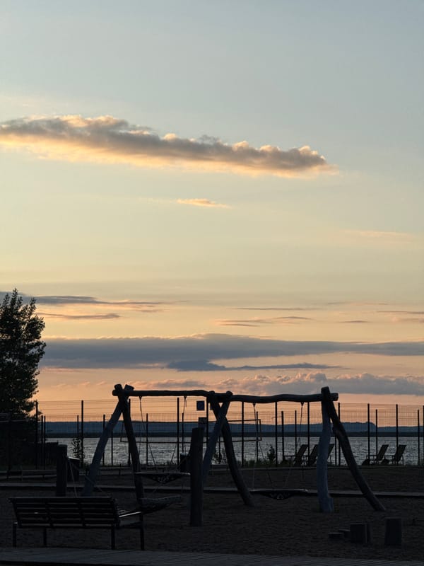 Child plays with toy truck on Chaikovsky shoreline at sunset