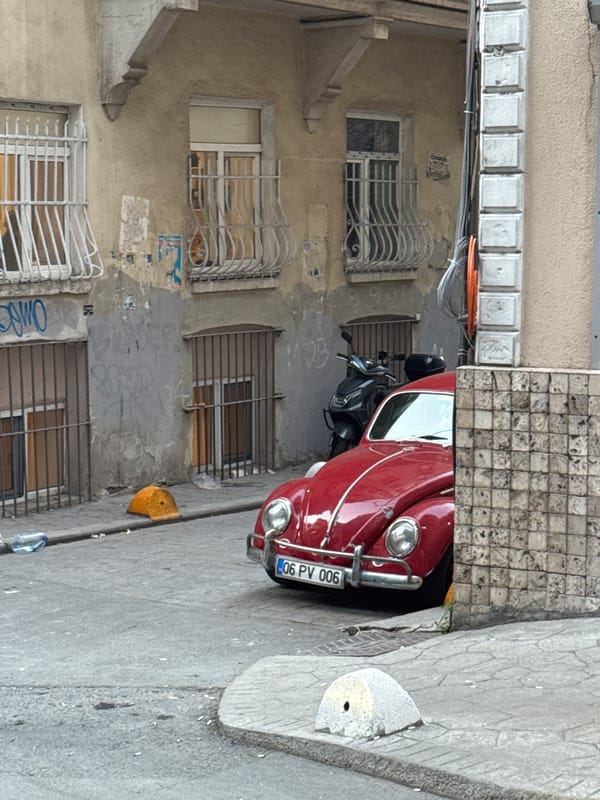 Classic red Volkswagen Beetle spotted on narrow Beyoğlu street