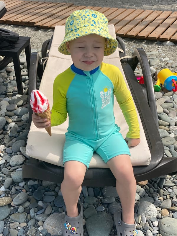 Child enjoys ice cream at Sochi beach morning