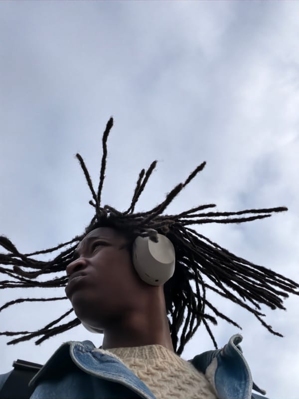 Person with dreadlocks gazes skyward in Rosny-sous-Bois
