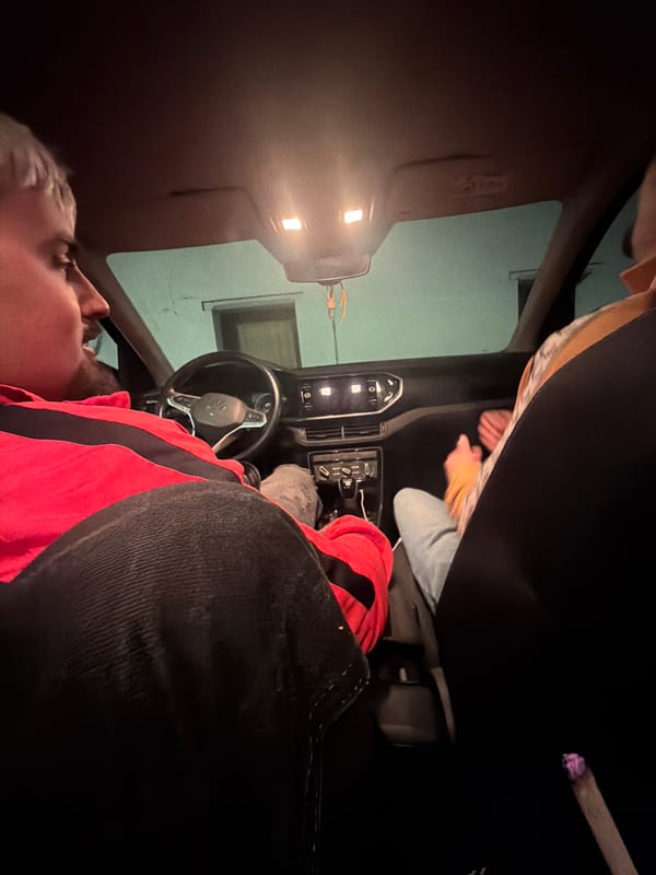 Person lying in driver's seat of car in Vila Real