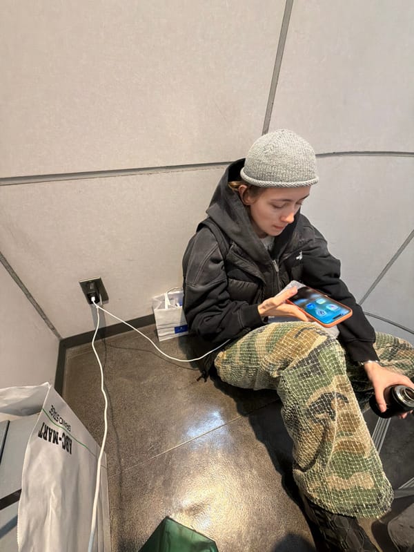 Person sits in Chuo public space, TGIF display observed