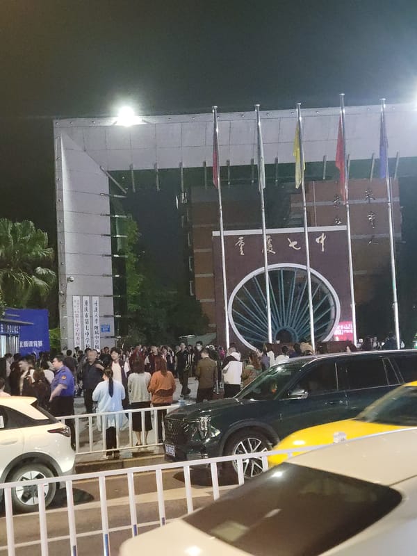 Crowd gathers behind barriers at China campus event