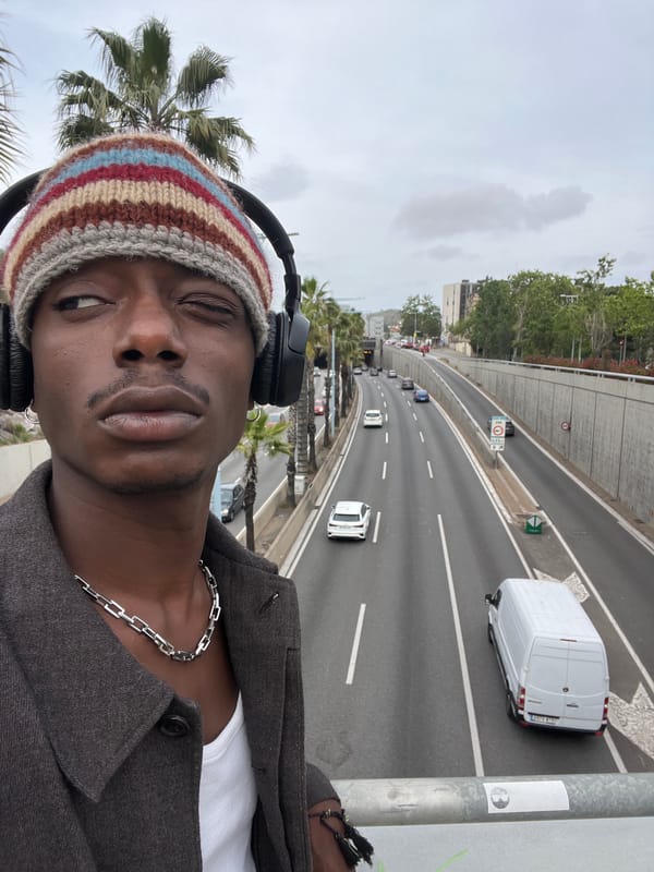 Man takes selfie on Barcelona bridge wearing colorful beanie