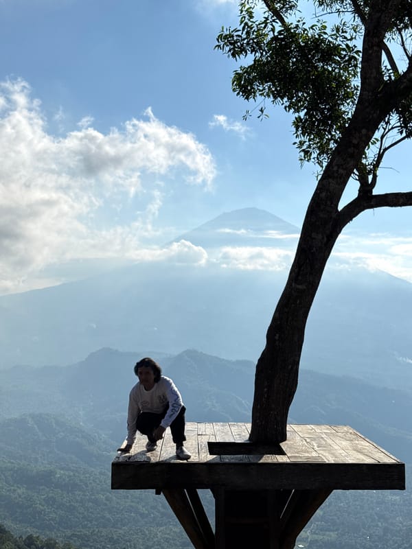 Hilltop platform overlooks misty valley and mountain near Abang