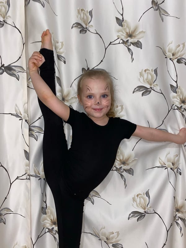 Young gymnast with cat face paint performs splits in Votkinsk