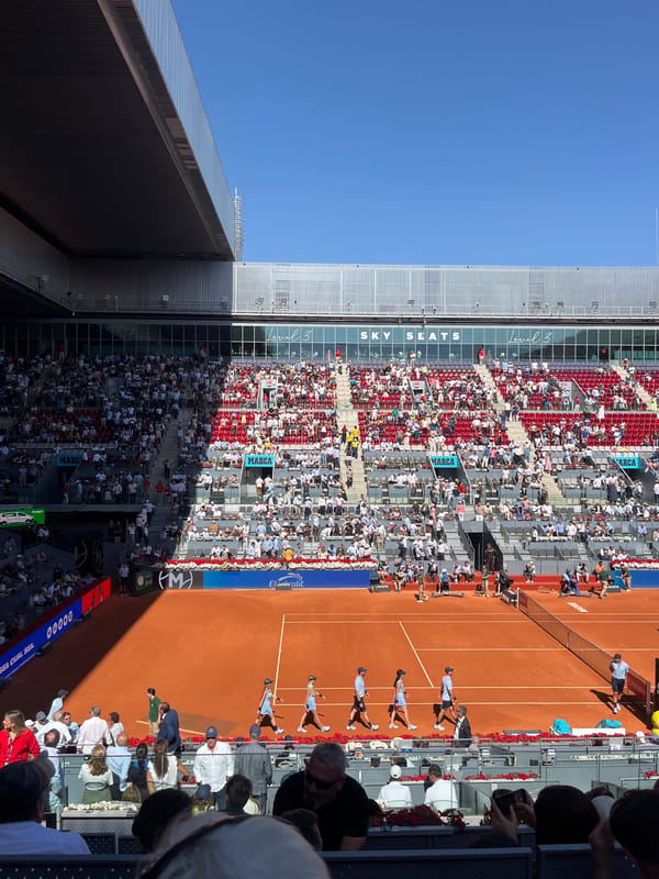 Professional tennis match underway on clay court in Madrid