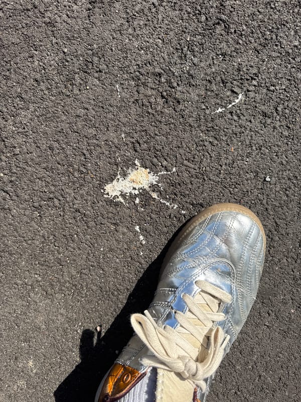 Person rests on pavement in distinctive footwear, Folkestone district
