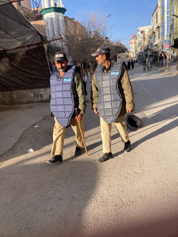 Roadside interaction between civilian and uniformed official in Quetta