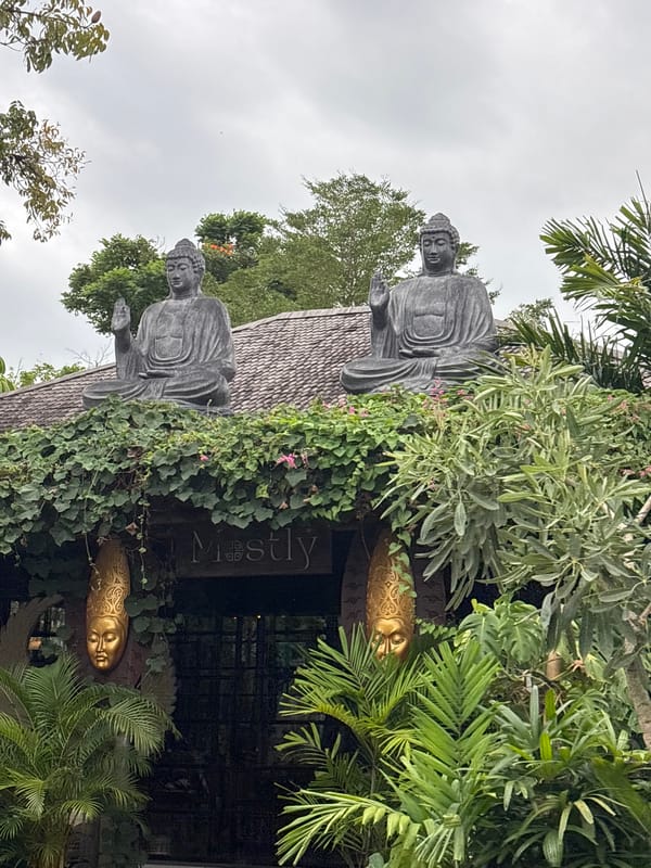 Buddha statues mark ivy-covered entrance in Mengwi, Indonesia