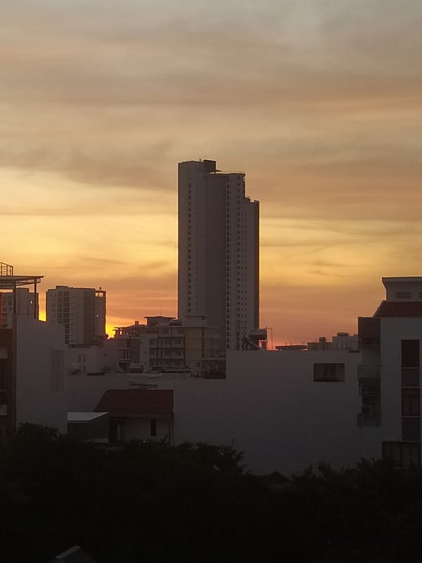 City skyline glowing through a golden-hour sunset