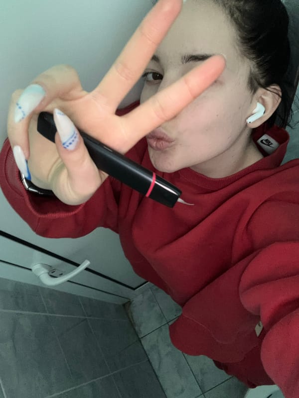 Woman with Nike sweatshirt uses electronic device in Sofia