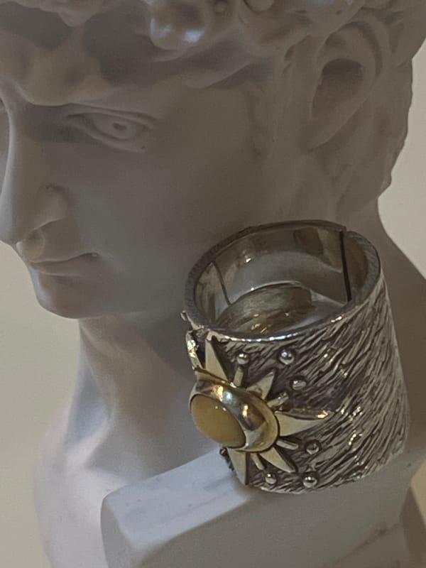 Classical bust and sunburst ring captured in close detail