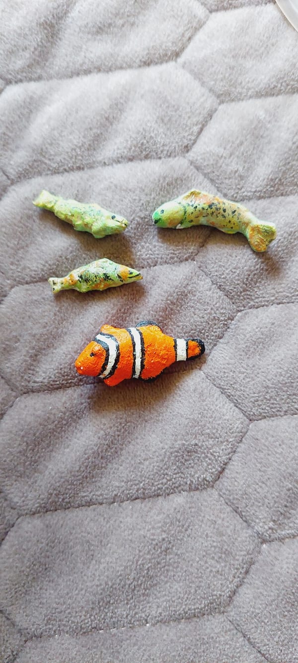 Handmade figurines arranged and shot on quilted fabric
