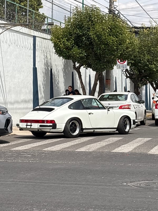 Man photographed with iPhone near white Porsche in Puebla