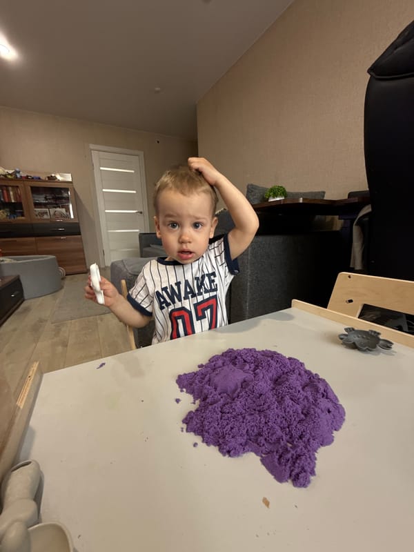 Child plays with purple kinetic sand in Rusanovo home
