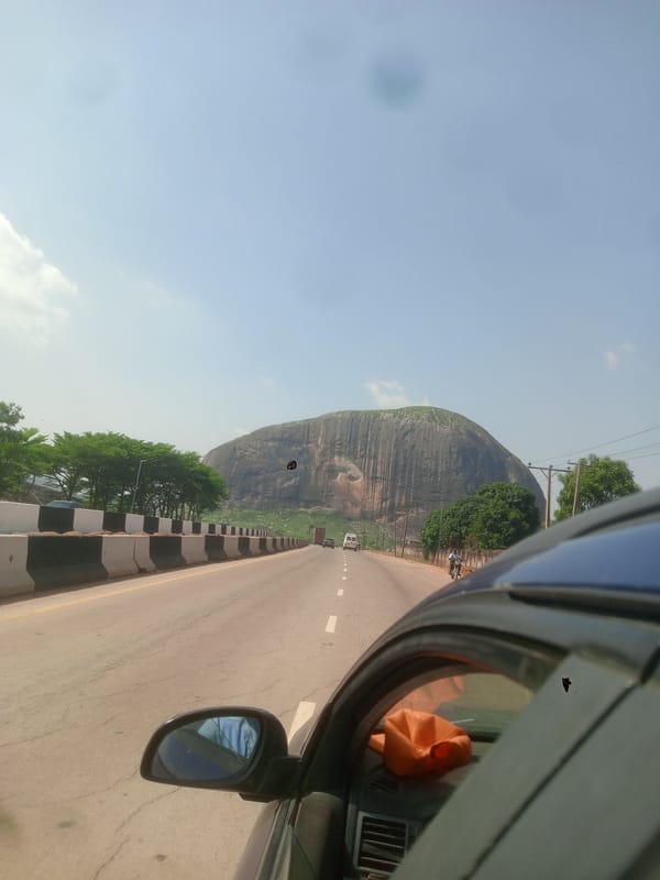Highway journey past rock formation documented by car passenger