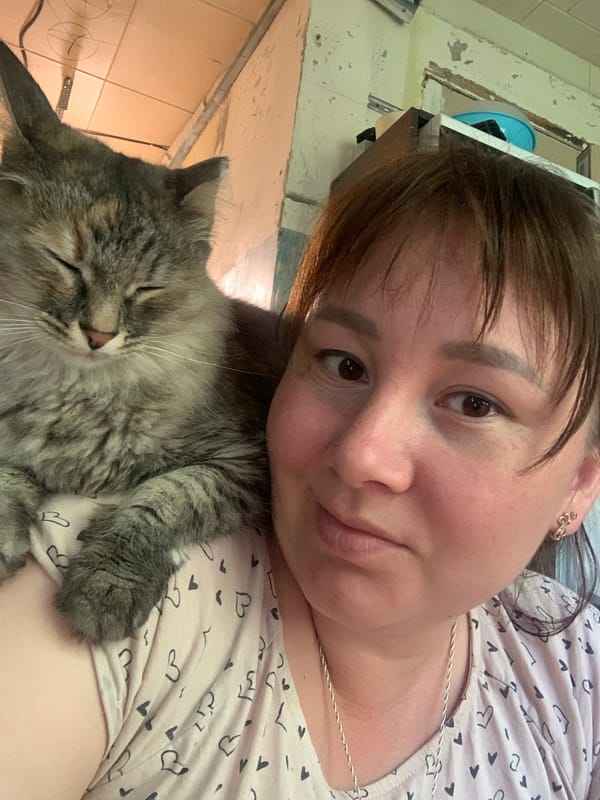 Woman rests with gray cat in Izhevsk