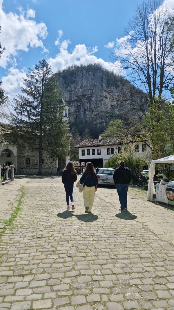 Pedestrians observed near traditional buildings in Bulgarian mountain region