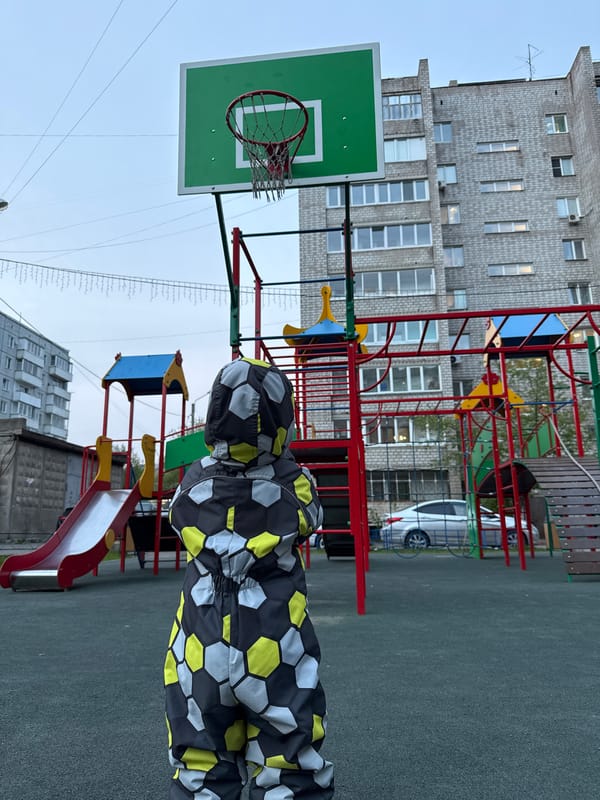 Child plays at Krasnoyarsk playground in soccer jumpsuit