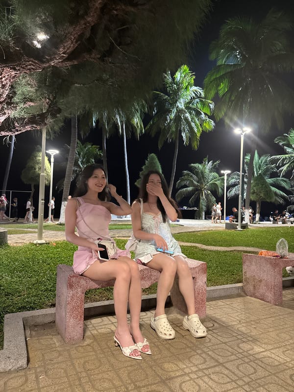Two women share evening moment on Nha Trang bench