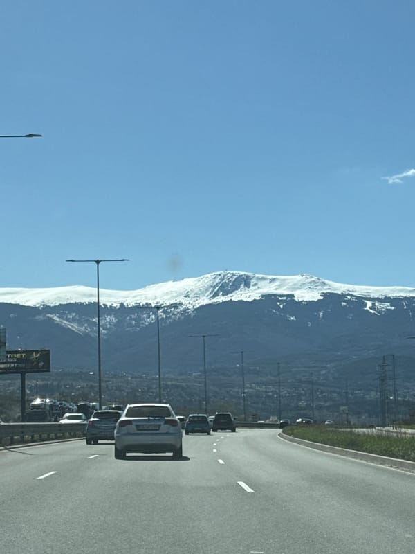 Traffic flows past snow-capped mountains in Lozen, Bulgaria