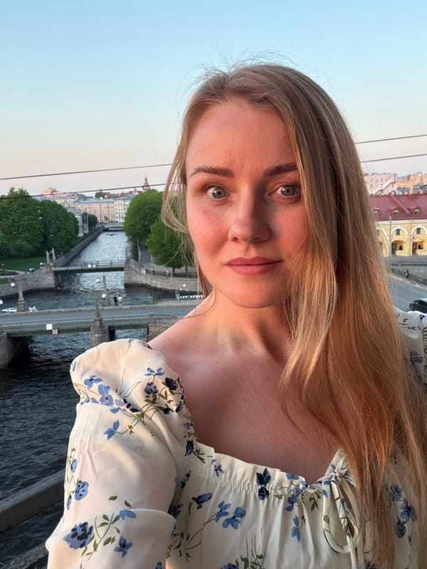 Woman takes sunset selfies overlooking Saint Petersburg riverscape