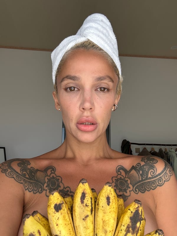 Woman with tattoos holds bananas in Kuta Selatan