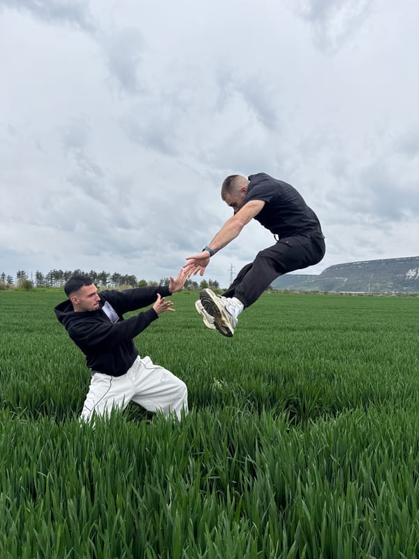 Two men pose synchronously in Bulgarian countryside landscape