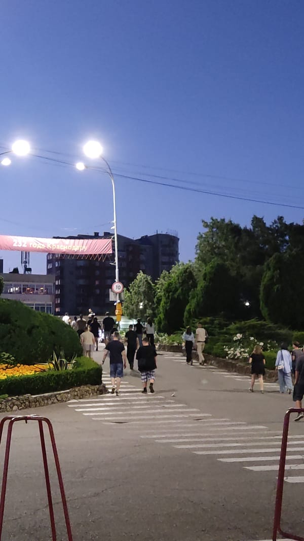 Krasnodar at dusk: waterfront, amusement rides, and an upside-down house
