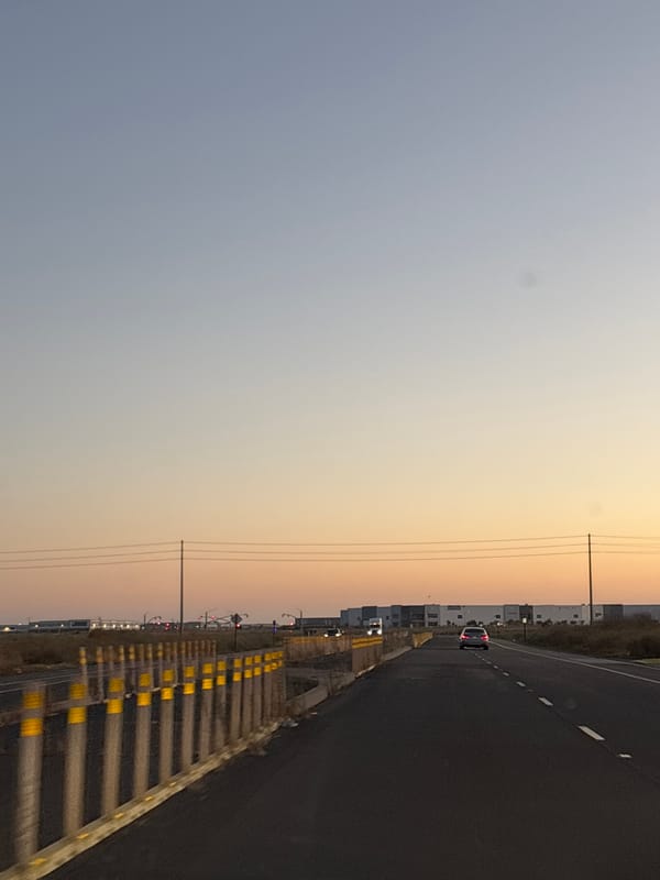Highway approach to a Sacramento industrial complex at golden hour
