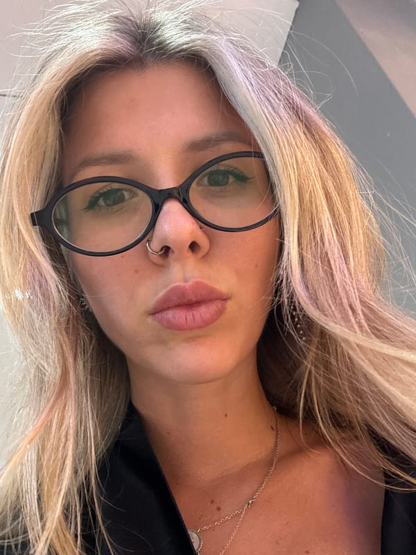 Close-up selfie with colorful hair highlights and oval glasses