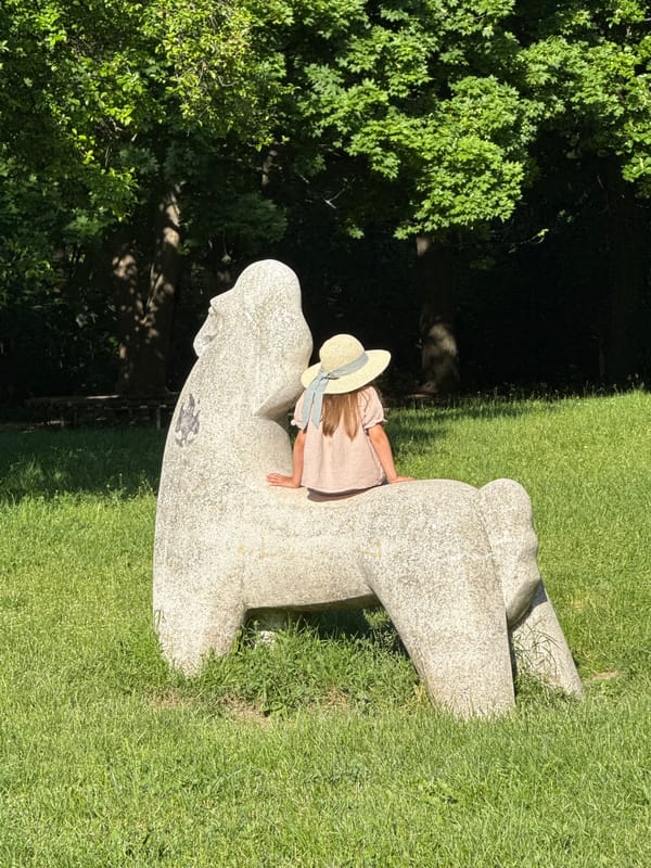 Children play near stone sculpture in Sofia park