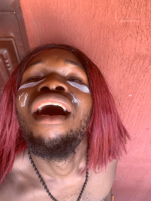 Person with pink hair photographs selfies in Nkpor, Nigeria