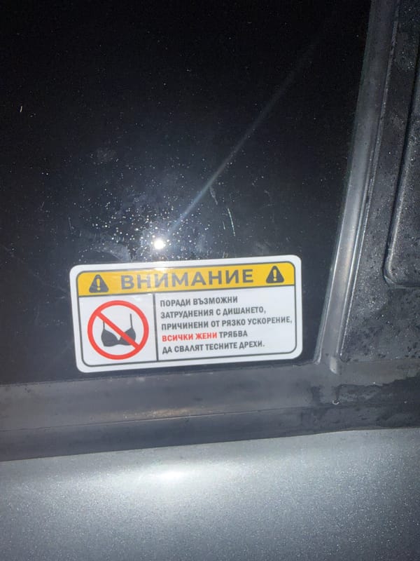 Alfa Romeo parked at night in Burgas, offensive sticker on display