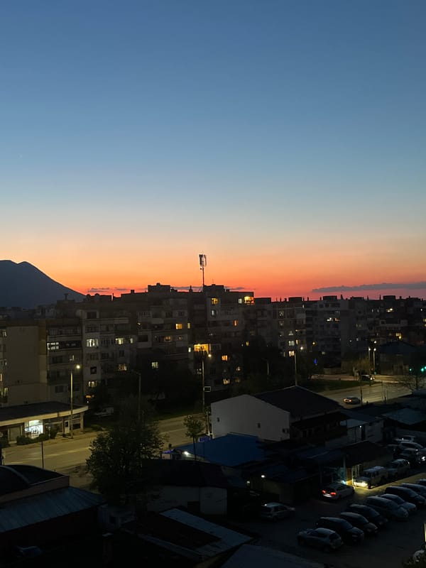 Evening lights illuminate residential Vratsa under twilight sky