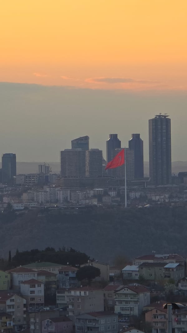 Turkish flag prominently displayed over Üsküdar skyline at dusk