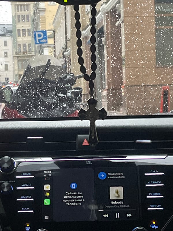 Vehicle interior documented with rosary hanging from dashboard