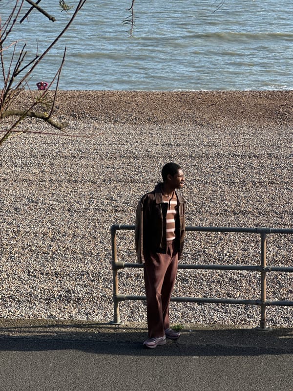 Man lies across beach railing in Folkestone district