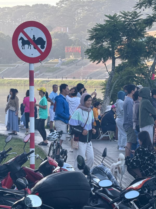 Cyclists, scooters, and locals along Da Lat's Xuan Huong Lake