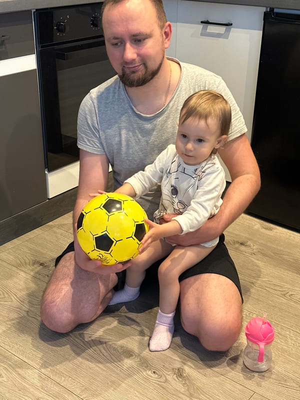 Father and child share quiet moment on floor in Wisła