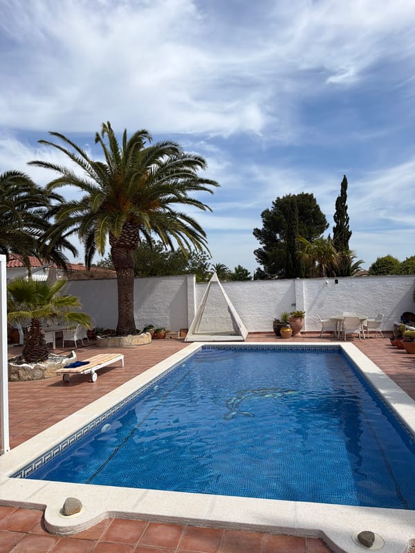 Man examines pool drain in Mont-roig del Camp courtyard