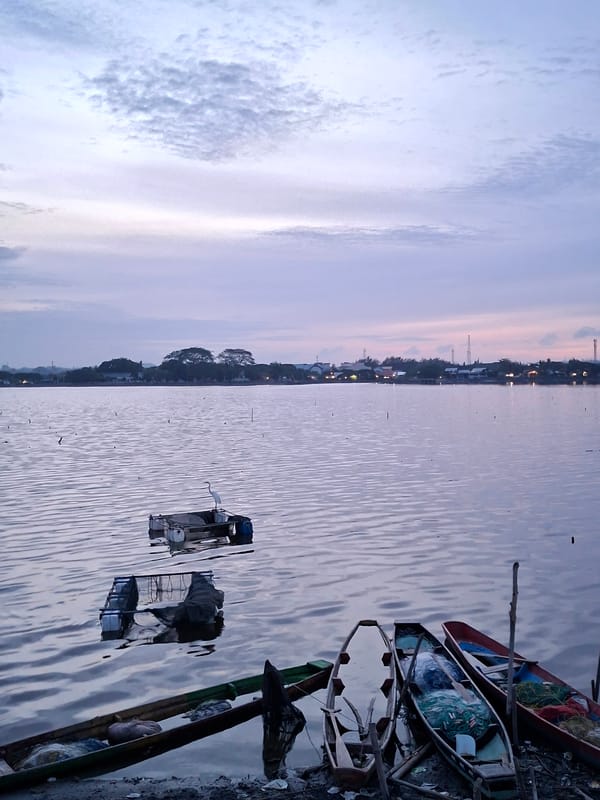Daily life documented along Lhokseumawe waterfront amid debris-filled waters
