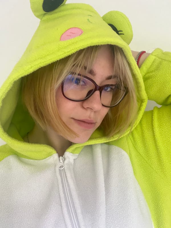 Person in frog costume poses with cats in Montenegro