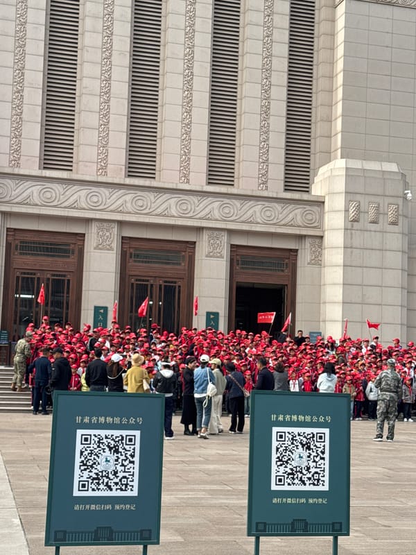 Children in red gather with flags at Chinese building