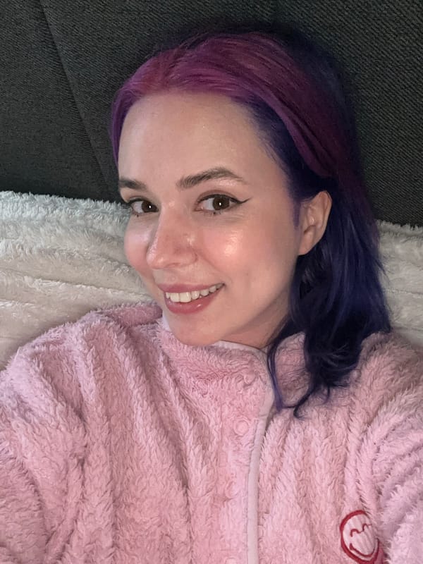 Woman in pink robe rests on couch in Zagreb
