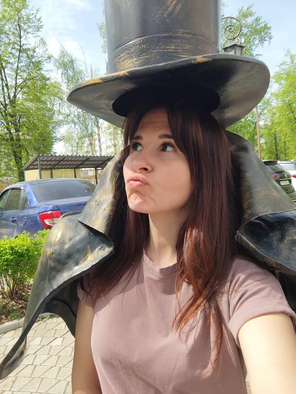 Tourists pose with top hat statue in Chaikovsky, Russia