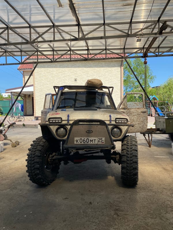 Woman poses with muddy off-road vehicle in Artyom, Russia