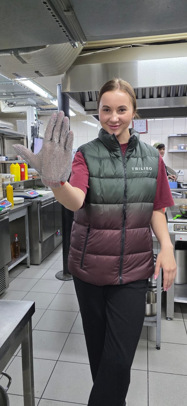Woman displays metal mesh glove in Ukrainian commercial kitchen